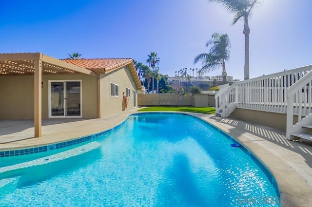 view of swimming pool with a wooden deck, a patio area, and a pergola