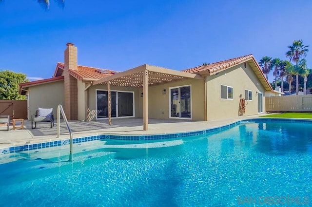 rear view of house featuring a fenced in pool, a patio, and a pergola