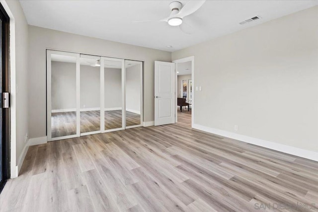 unfurnished bedroom featuring ceiling fan, light hardwood / wood-style floors, and a closet