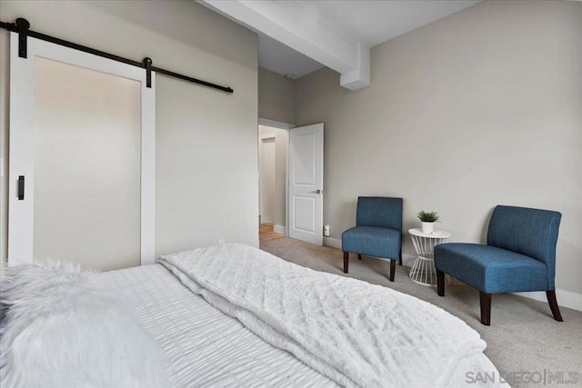 bedroom featuring light carpet, beam ceiling, and a barn door