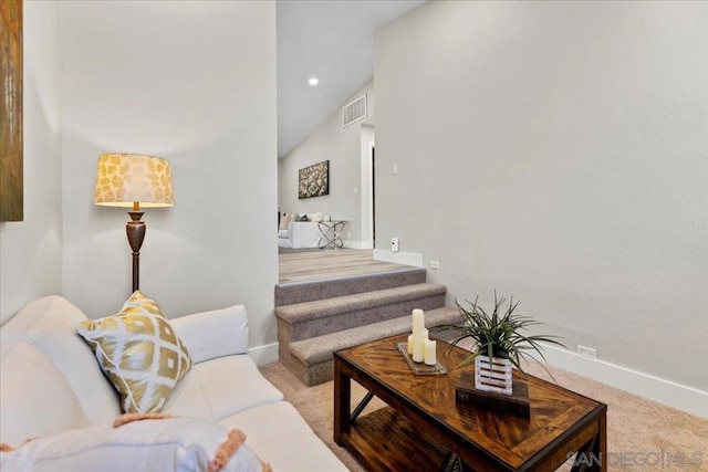 living room featuring lofted ceiling and light colored carpet