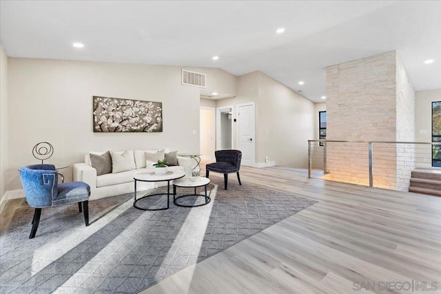 living room with lofted ceiling and light wood-type flooring