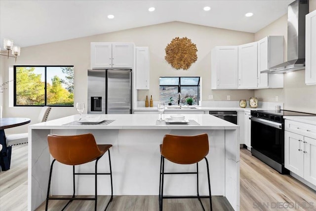 kitchen with range with electric cooktop, lofted ceiling, wall chimney range hood, and stainless steel fridge with ice dispenser