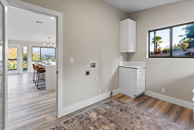 clothes washing area featuring an inviting chandelier, washer hookup, light hardwood / wood-style floors, and electric dryer hookup