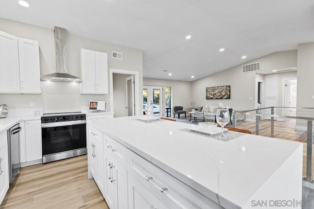 kitchen featuring french doors, range with electric stovetop, dishwasher, wall chimney range hood, and white cabinets