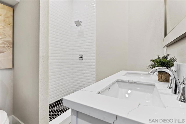 bathroom with vanity, a shower, and toilet