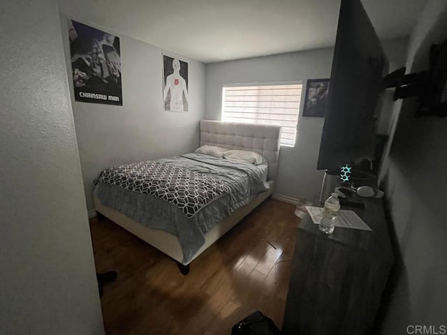 bedroom with dark wood-type flooring