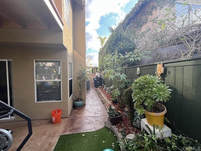 view of side of property with central AC unit and a patio area