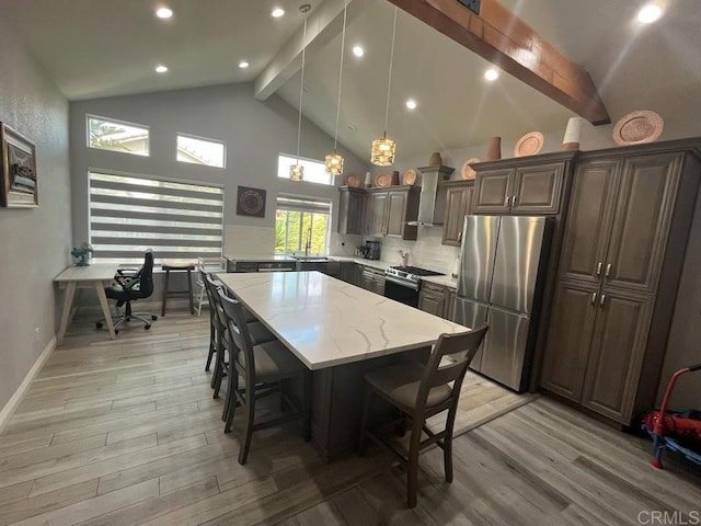 kitchen featuring appliances with stainless steel finishes, a center island, dark brown cabinets, and light wood-type flooring