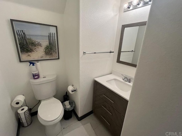 bathroom featuring vanity, tile patterned floors, and toilet