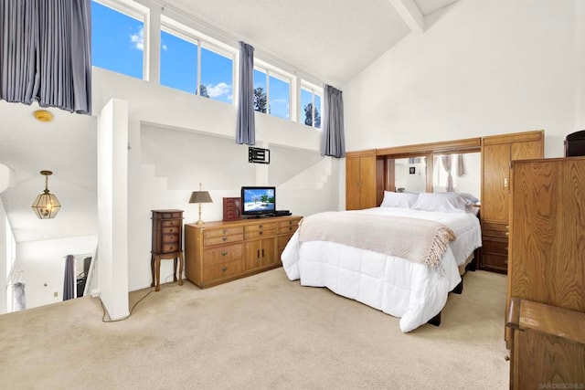 carpeted bedroom featuring beamed ceiling and high vaulted ceiling