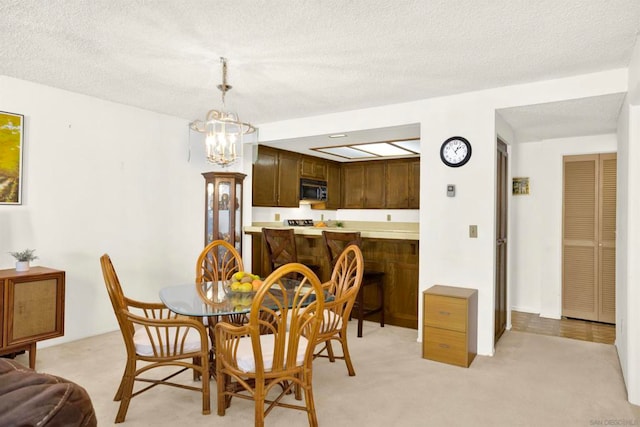 carpeted dining area featuring a textured ceiling and an inviting chandelier