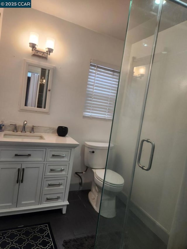 bathroom with vanity, toilet, tile patterned floors, and walk in shower