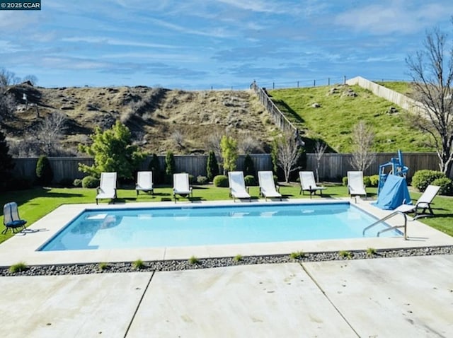 view of pool featuring a lawn and a patio area