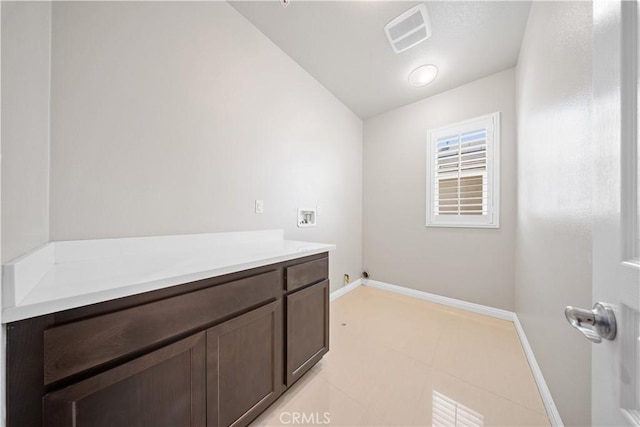 clothes washing area with light tile patterned floors and hookup for a washing machine