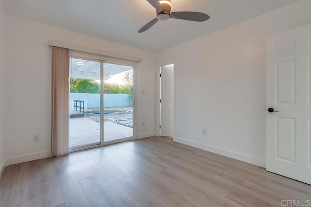 empty room featuring light wood-type flooring, a ceiling fan, and baseboards