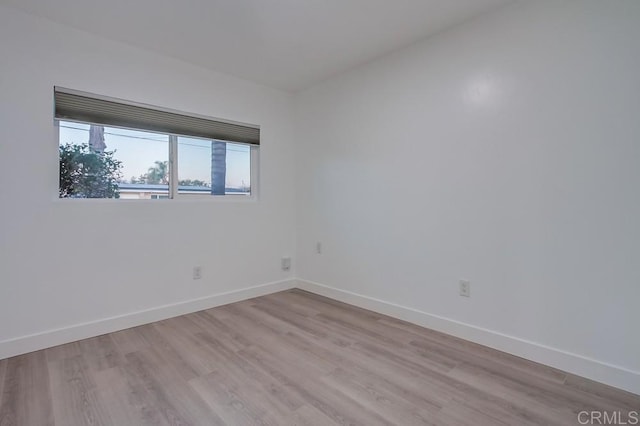 unfurnished room with light wood-style flooring and baseboards