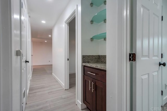 corridor featuring light wood-style flooring, baseboards, and recessed lighting