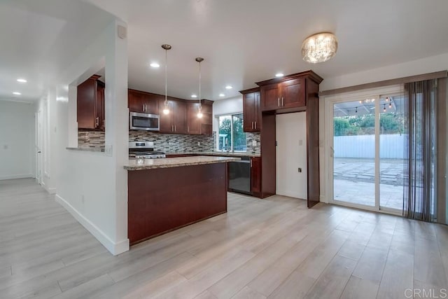 kitchen with appliances with stainless steel finishes, backsplash, light wood finished floors, and a peninsula