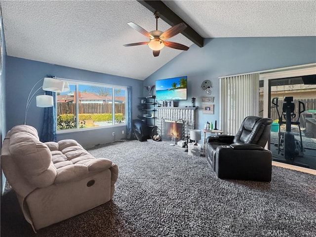 carpeted living room featuring ceiling fan, a fireplace, lofted ceiling with beams, and a textured ceiling