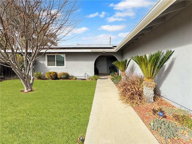 property entrance featuring a yard and solar panels