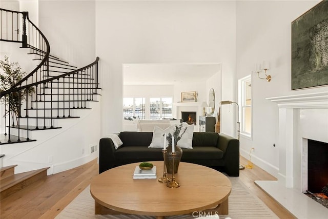 living room with light hardwood / wood-style floors and a high ceiling