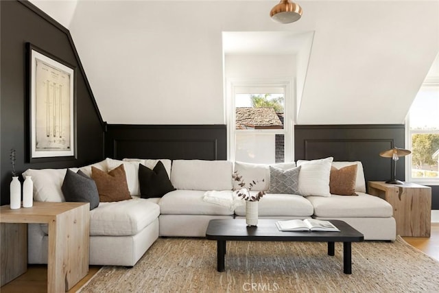 living room with hardwood / wood-style floors, vaulted ceiling, and a wealth of natural light