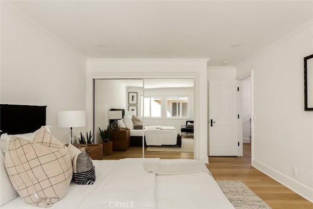 bedroom featuring ornamental molding, hardwood / wood-style floors, and a closet