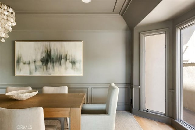 dining space featuring ornamental molding and light hardwood / wood-style flooring