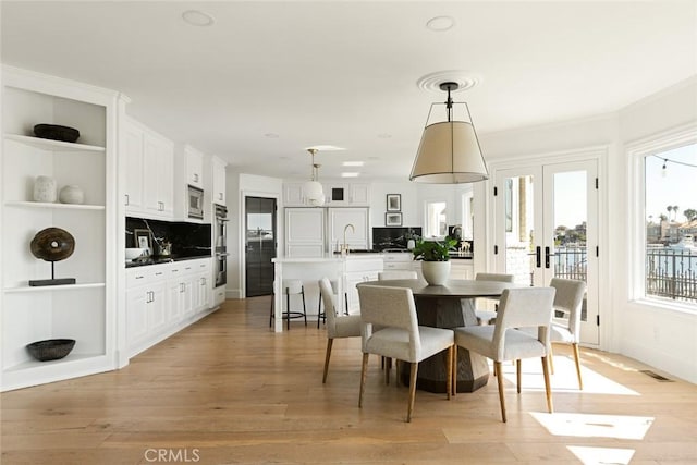 dining area with sink and light hardwood / wood-style floors