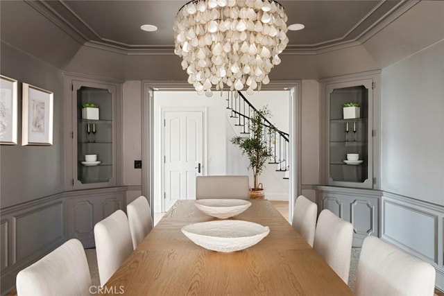 dining room with ornamental molding, an inviting chandelier, and built in shelves