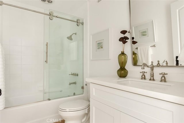 full bathroom with bath / shower combo with glass door, vanity, and toilet