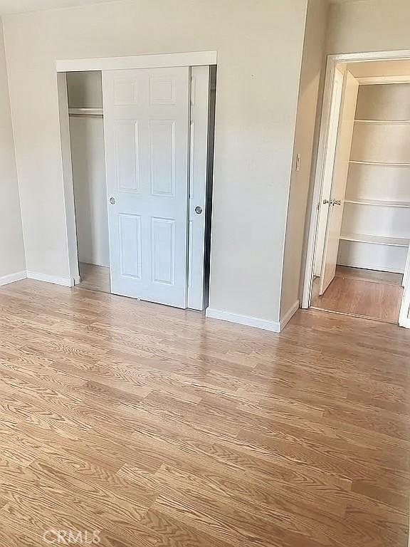 unfurnished bedroom with hardwood / wood-style flooring and a closet