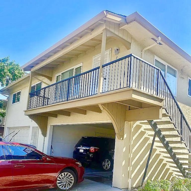 view of side of home with a garage and a balcony