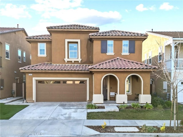 mediterranean / spanish home with a garage and covered porch