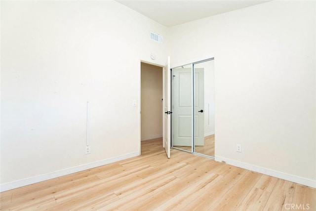 unfurnished bedroom featuring hardwood / wood-style flooring and a closet