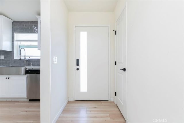 foyer entrance featuring sink and light hardwood / wood-style floors