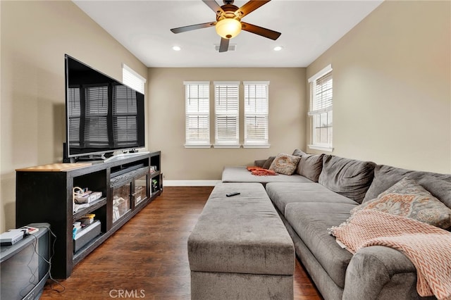 living room featuring dark wood-type flooring and ceiling fan