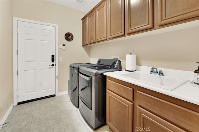 washroom featuring sink, cabinets, and independent washer and dryer