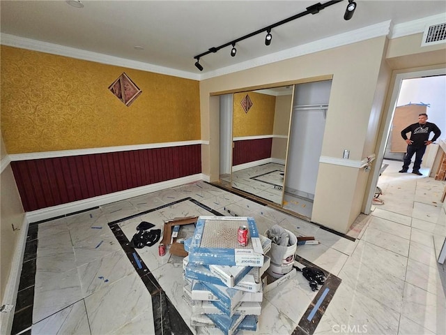 interior space featuring crown molding and rail lighting