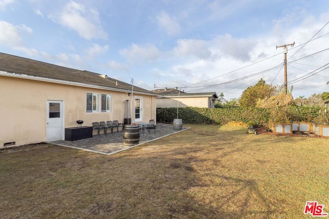 back of property with a yard and a patio area