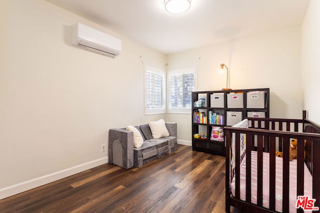 bedroom with dark hardwood / wood-style floors, an AC wall unit, and a nursery area