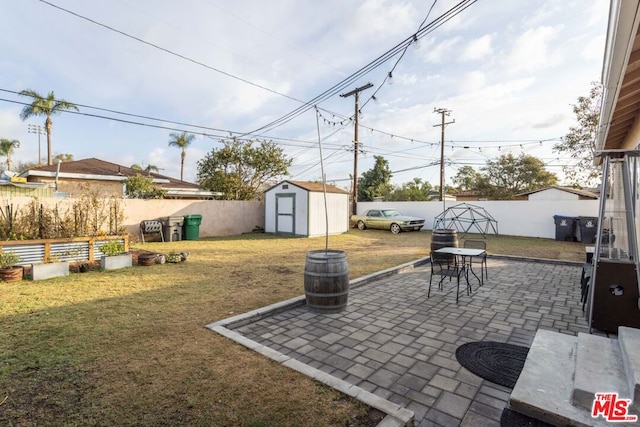 view of yard featuring a storage unit and a patio