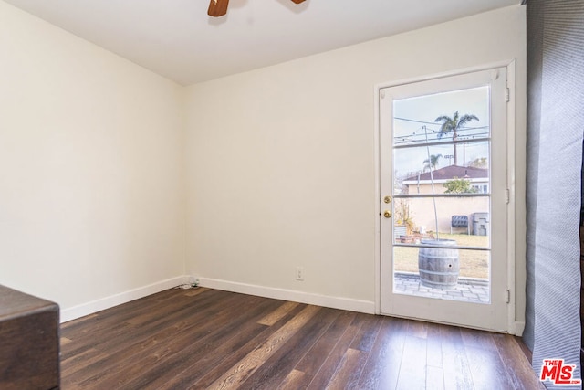 spare room featuring dark wood-type flooring and ceiling fan