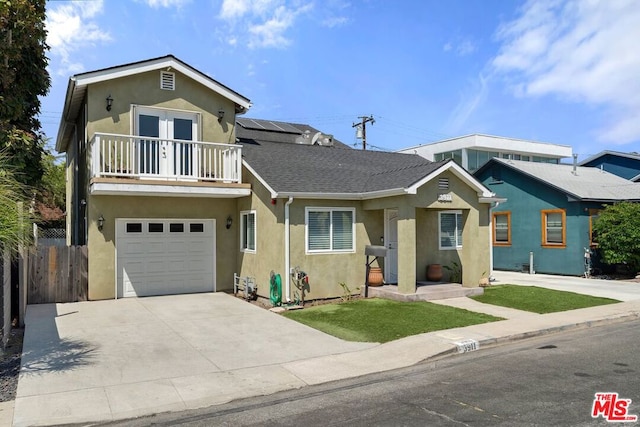 view of front of property featuring a garage, a balcony, and solar panels