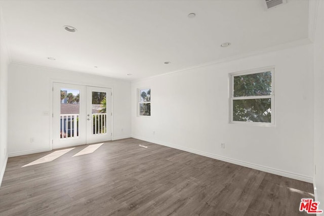 empty room with crown molding, dark wood-type flooring, and french doors