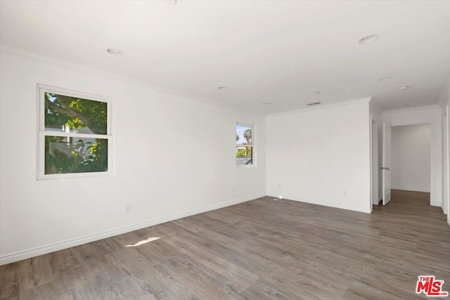 spare room with dark hardwood / wood-style flooring and crown molding