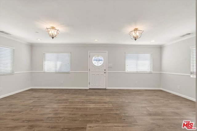 foyer entrance featuring crown molding, a chandelier, and hardwood / wood-style floors