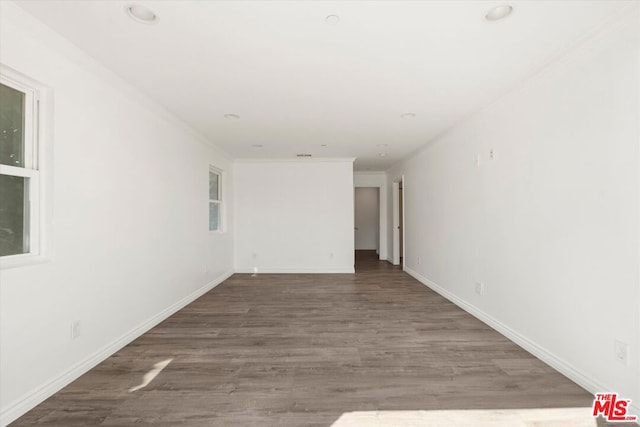 empty room with hardwood / wood-style floors and ornamental molding