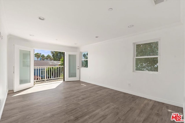 unfurnished room with crown molding, wood-type flooring, and french doors